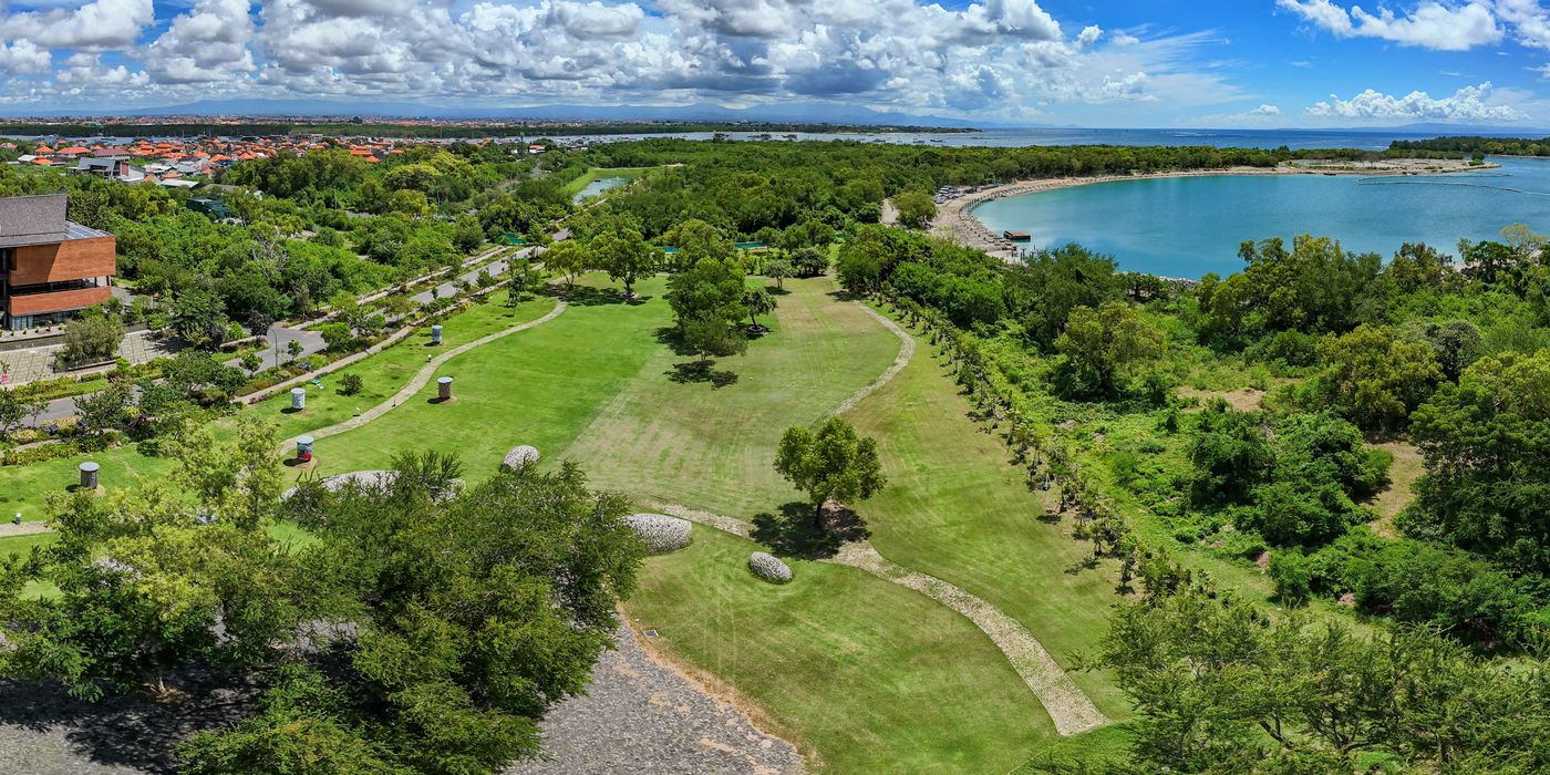 Aerial view of landscaped parkland running down to the coast in south Bali