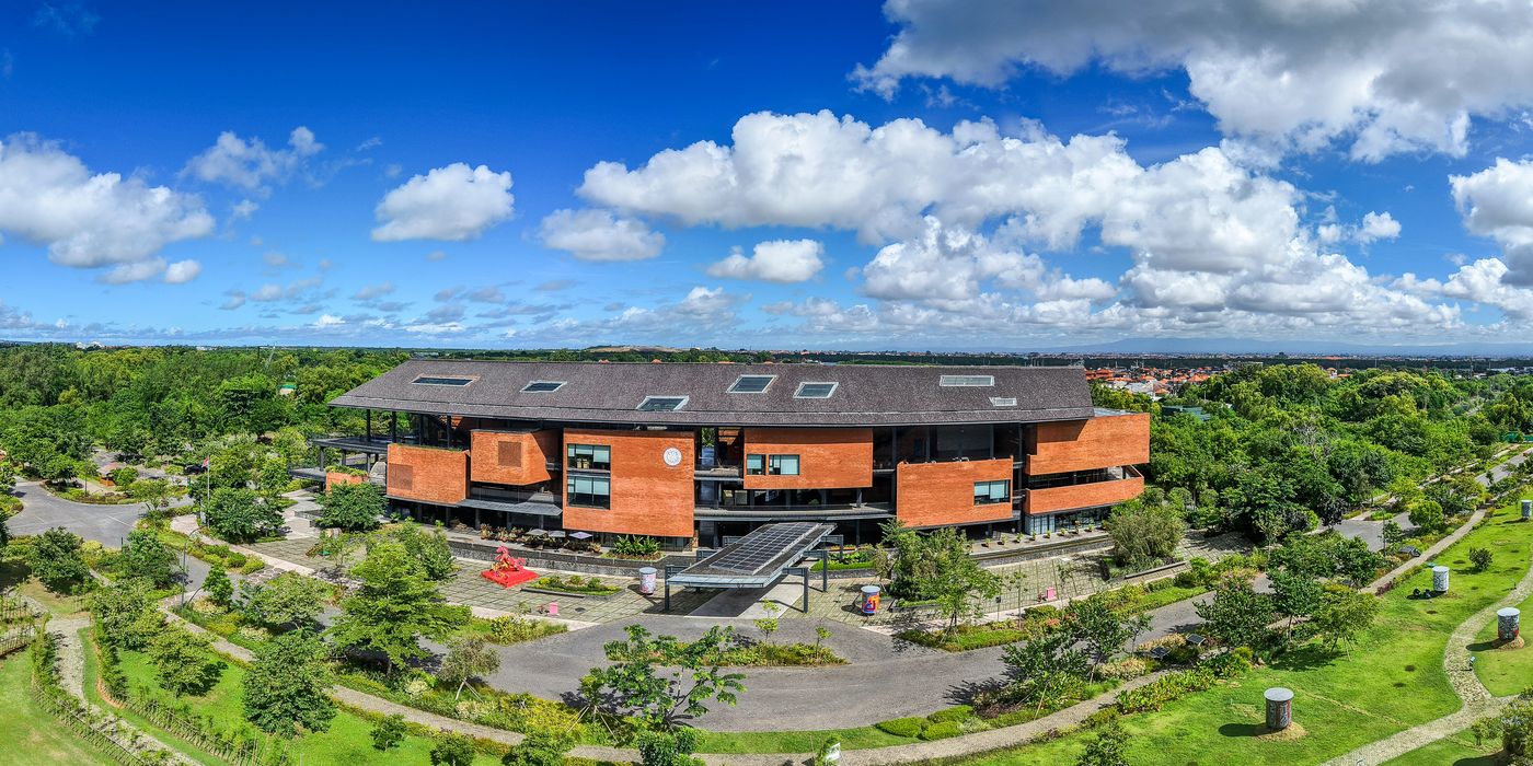 Aerial view of a completed development building on a Bali coastal site, with parkland and paths laid out around it
